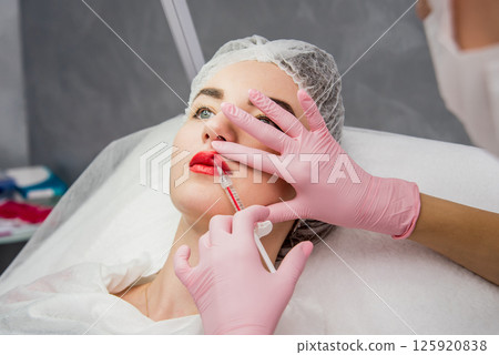 The doctor cosmetologist makes the facial injections procedure. The doctor cosmetologist makes the facial injections procedure. 125920838