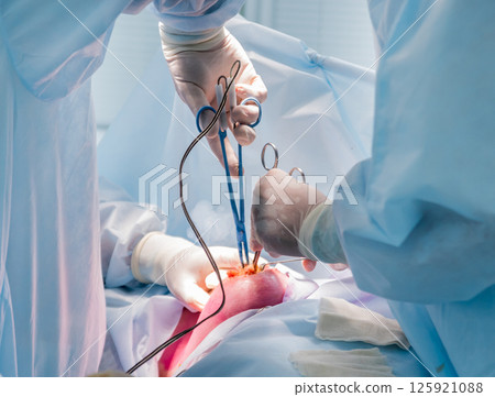 Surgeon and assistants in operating room with surgery equipment. Surgeon and assistants in operating room with surgery equipment. 125921088