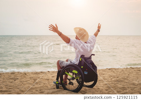Disabled man in a wheelchair on the beach. 125921115