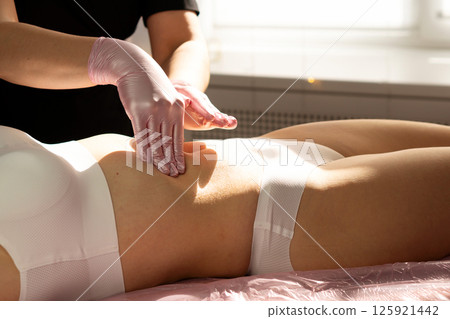 Hands massage abdomen gently in final step of honey therapy. Hands massage abdomen gently in final step of honey therapy. 125921442