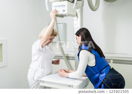Radiologist and patient in a x-ray room. X-ray of human hand. 125921505