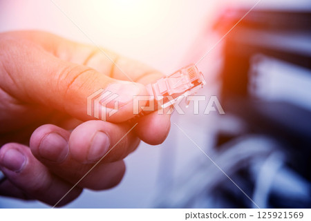 Technician connecting network cables to switches. Connecting cables Technician connecting network cables to switches. Connecting cables 125921569