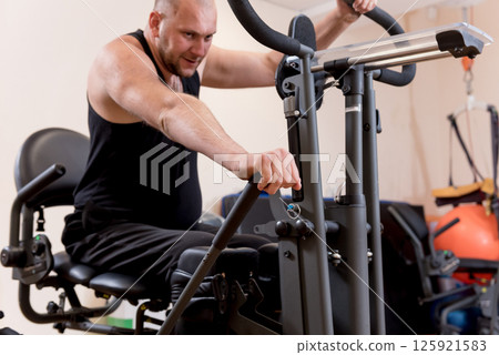 Disabled man training in the gym. Rehabilitation center Disabled man training in the gym. Rehabilitation center 125921583
