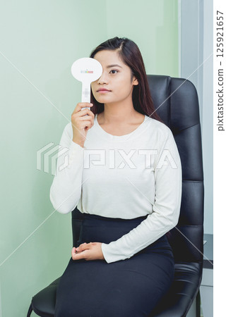 Consultation with an ophthalmologist. Young asian woman in clinic office. 125921657