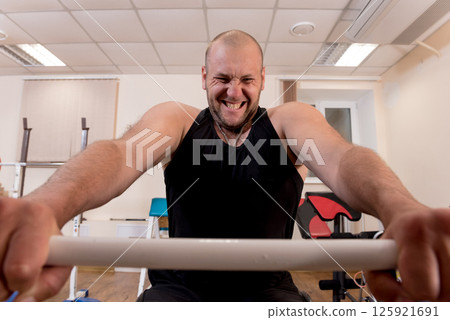 Disabled man training in the gym. Rehabilitation center Disabled man training in the gym. Rehabilitation center 125921691