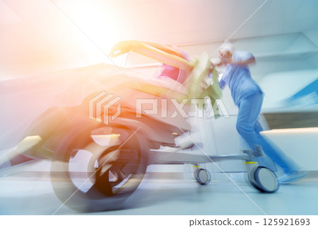 Nurse moves mobile medical chair with patient at hospital. Medical equipment. 125921693