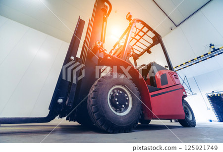 Forklift in a large industrial freezer warehouse.  125921749