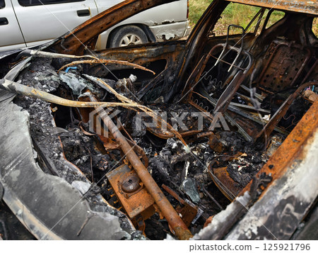 Charred remnants of a vehicle interior left behind after a devastating fire incident Charred remnants of a vehicle interior left behind after a devastating fire incident 125921796