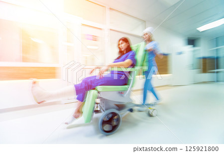 Nurse moves mobile medical chair with patient at hospital. Medical equipment. Nurse moves mobile medical chair with patient at hospital. Medical equipment. 125921800