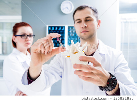 Doctors team having medical council in hospital. Spine fixation systems Doctors team having medical council in hospital. Spine fixation systems 125921983