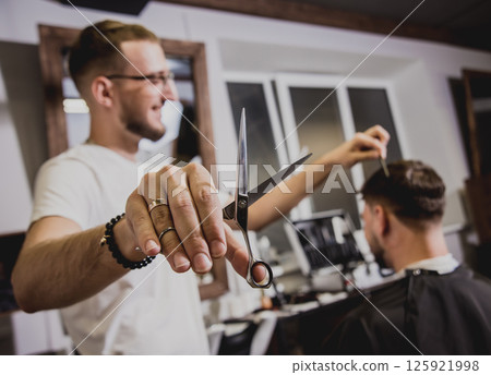 Young man with trendy haircut at barber shop. Young man with trendy haircut at barber shop. 125921998