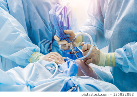 Arthroscope surgery. Orthopedic surgeons in teamwork in the operating room Arthroscope surgery. Orthopedic surgeons in teamwork in the operating room 125922098