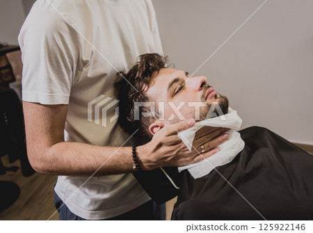 Young man with trendy haircut at barber shop. Young man with trendy haircut at barber shop. 125922146