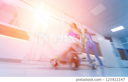Nurse moves mobile medical chair with patient at hospital. Medical equipment. Nurse moves mobile medical chair with patient at hospital. Medical equipment. 125922147