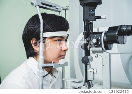 Consultation with an ophthalmologist. Young asian man and woman doctor Consultation with an ophthalmologist. Young asian man and woman doctor 125922415