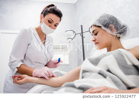 The doctor cosmetologist makes cosmetology dropper procedure. Infusion.  125922477
