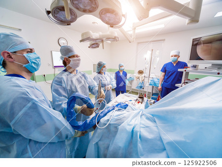 Arthroscope surgery. Orthopedic surgeons in teamwork in the operating room Arthroscope surgery. Orthopedic surgeons in teamwork in the operating room 125922506