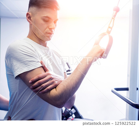 Rehabilitation therapy. Young man doing exercises on mat  125922522