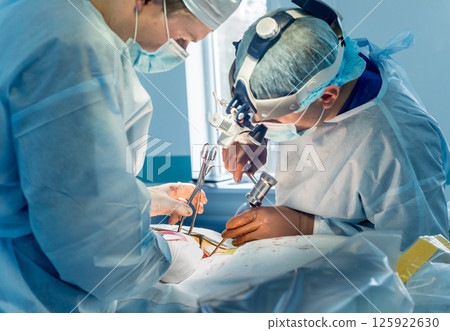 Spinal surgery. Group of surgeons in operating room with surgery equipment.  125922630