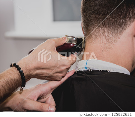 Young man with trendy haircut at barber shop. Young man with trendy haircut at barber shop. 125922631