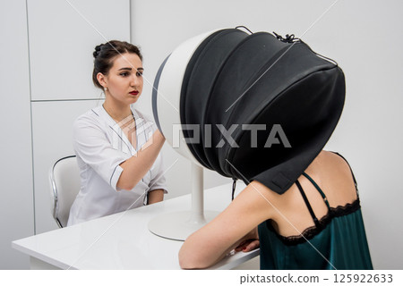 Face skin analyze system. Cosmetologist analyzing woman face.  125922633