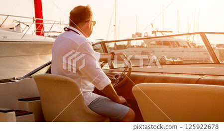 Young man on sailing yacht. Hands hold steering wheel Young man on sailing yacht. Hands hold steering wheel 125922678