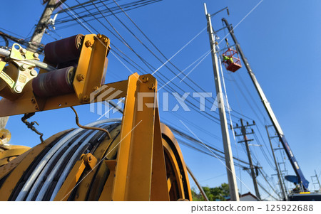 Installation of high-voltage electric wires on new poles along the road Installation of high-voltage electric wires on new poles along the road 125922688