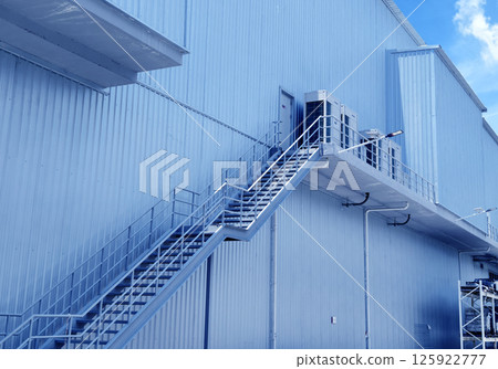 A set of stairs ascending a large blue wall A set of stairs ascending a large blue wall 125922777