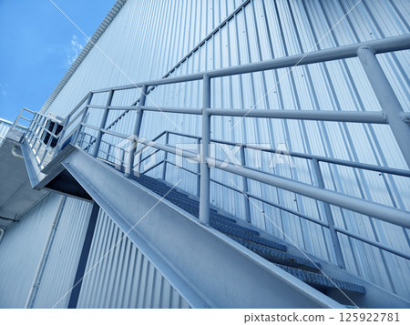 A set of stairs ascending a large blue wall 125922781