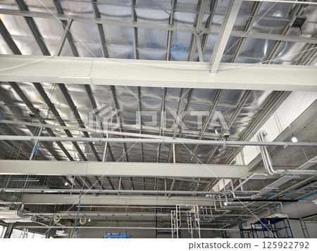 The ceiling of a large building under construction an extensive network of pipes The ceiling of a large building under construction an extensive network of pipes 125922792