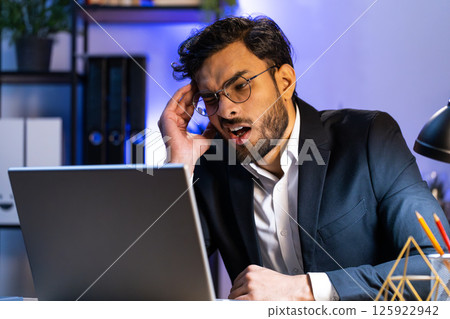 Tired Indian business man suffering from headache problem tension, migraine, stress at home office Tired Indian business man suffering from headache problem tension, migraine, stress at home office 125922942