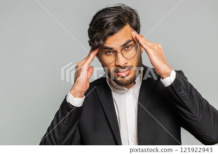 Indian man rubbing temples to cure headache problem, suffering from tension and migraine stress pain Indian man rubbing temples to cure headache problem, suffering from tension and migraine stress pain 125922943