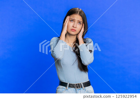 Young woman rubbing temples to cure headache problem suffering from tension and migraine stress pain 125922954