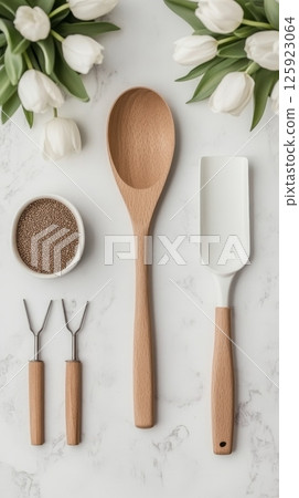 Wooden and white kitchen utensils with tulips and spices on marble countertop Wooden and white kitchen utensils with tulips and spices on marble countertop 125923064