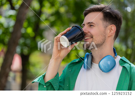 Happy man enjoying morning coffee hot drink and smiling relaxing, taking a break on city street 125923152