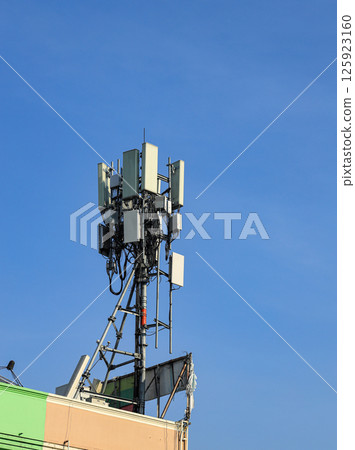 Wireless Communication Antenna pole, Mobile phone mast antenna pole on top of dilapidated building. Wireless Communication Antenna pole, Mobile phone mast antenna pole on top of dilapidated building. 125923160