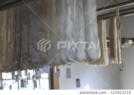 精緻的絲線掛在外面晾乾。絲綢織物加工。 125923219