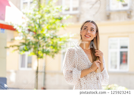 Thoughtful smiling happy young woman with pensive expression pondering a solution dreaming thinking Thoughtful smiling happy young woman with pensive expression pondering a solution dreaming thinking 125923241