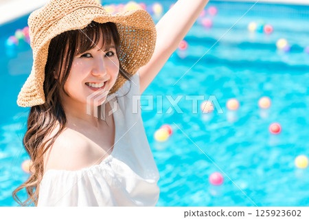 Young Asian woman in resort fashion by the pool at a resort (vacation, travel) 125923602