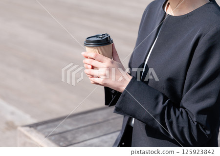 穿著西裝的年輕女子在戶外喝咖啡 125923842