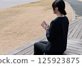 一位身穿西裝的年輕女子正在合上記事本 125923875