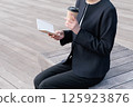 一位身穿西裝的年輕女子正在合上記事本 125923876