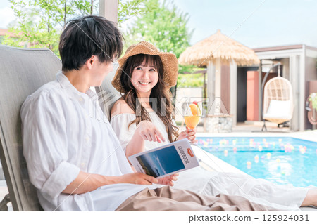 一對夫婦在旅行中坐在度假酒店的池畔椅上 一對夫婦在旅行中坐在度假酒店的池畔椅上 125924031