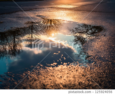 Sunset reflected in puddle 125924056