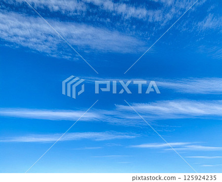 Background material of natural scenery with streaky cirrus clouds spreading across a clear blue summer sky, refreshing and bright sky pattern 125924235