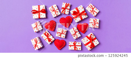 Composition of holiday white gift boxes and red textile hearts on colorful background. Valentine's day concept 125924245