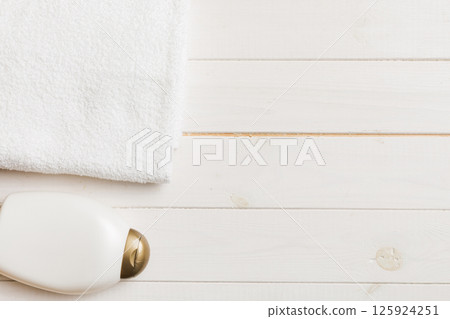 Cosmetic shampoo bottle mockup with towels on a colored table. Bathroom background, toilet accessories for hand and body care Cosmetic shampoo bottle mockup with towels on a colored table. Bathroom background, toilet accessories for hand and body care 125924251