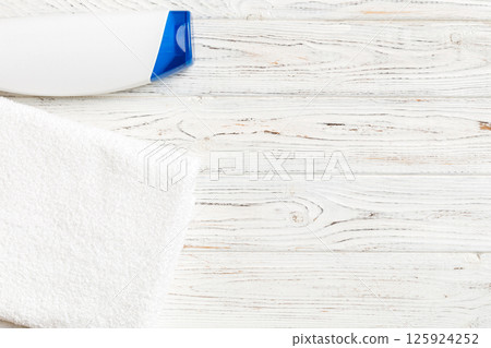 Cosmetic shampoo bottle mockup with towels on a colored table. Bathroom background, toilet accessories for hand and body care Cosmetic shampoo bottle mockup with towels on a colored table. Bathroom background, toilet accessories for hand and body care 125924252