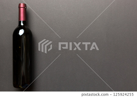 One Bottle of red wine on colored table. Flat lay, top view wth copy space 125924255