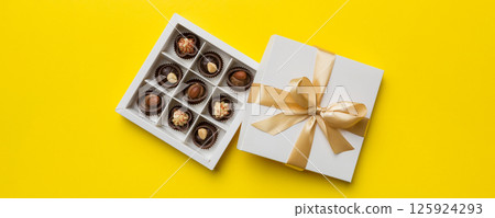 White box with chocolates candies and golden tape. top view with copy space 125924293